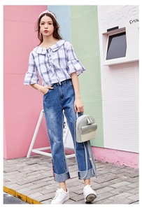 Outdoor street style view of a fashion backpack styled with a blue plaid blouse and jeans
