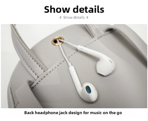 Detail showing the headphone jack with golden metal ring on grey leather backpack