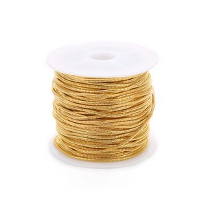 Macro detail of bulk gold snake bone chain roll wound on white plastic spool