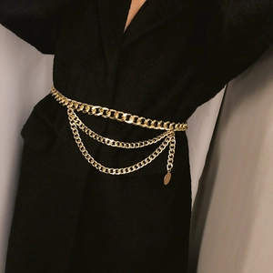 Three-layer gold body chain featuring a thick Cuban link and delicate pendant on a coat
