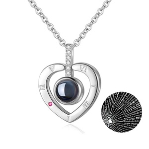 Macro shot of silver heart pendant showing 100 languages I Love You projection effect