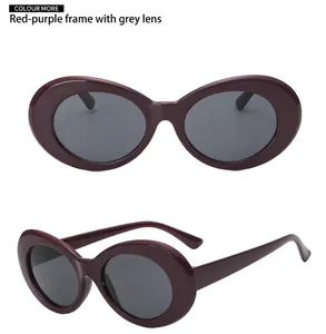 Detail view of oval plum red sunglasses featuring a wide frame and dark gray lenses