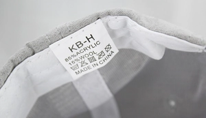 Detail view of baseball cap interior showing the grey fabric texture and white care label