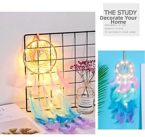 Detailed view of handmade light-up dreamcatcher with colorful feathers and warm LED lights