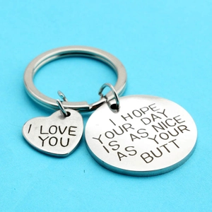 Macro detail of stainless steel keychain with funny engraved text and heart charm