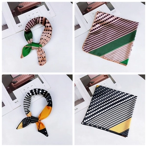 Detail of silk square scarves featuring polka dot patterns in pink-green and yellow-black