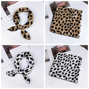 Detail of silk-like champagne and white square scarves with elegant heart prints
