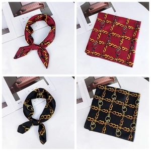 Close-up of silk neckerchief with golden chain print in burgundy and black colors