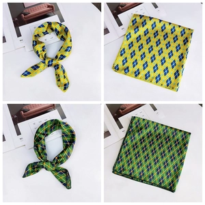 Close-up of geometric diamond pattern silk scarf with sleek satin texture in blue and yellow