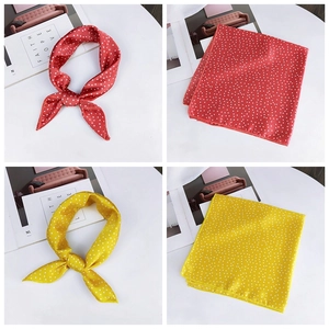 Detailed views of red and yellow polka dot satin silk scarves tied and folded neatly