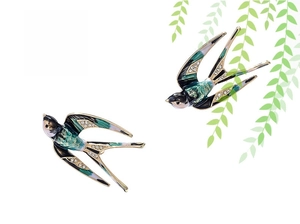 Detail of swallow brooches featuring green enamel finish and sparkling crystal wings