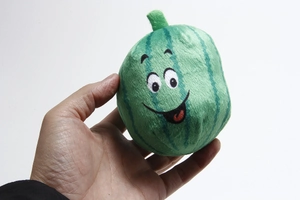 Close-up of small plush squeaky watermelon dog toy with embroidered smile detail