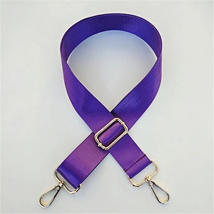 Detail of deep purple nylon bag strap with herringbone weave and gold metal swivel clasps