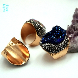 Macro shot of blue druzy crystal ring with hammered gold band and pavé stones