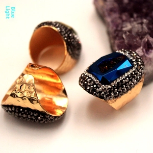 Detalle de anillo de piedra azul con banda martillada dorada y detalles de cristal