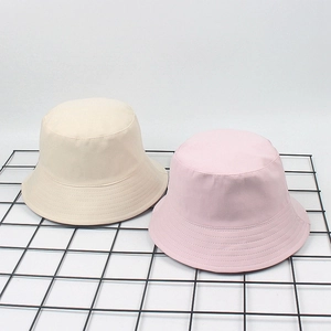 Detailed view of beige and pink cotton bucket hats featuring reinforced stitching on brim