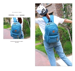 Close-up of sky blue washed canvas backpack with multiple pockets and star logo patch