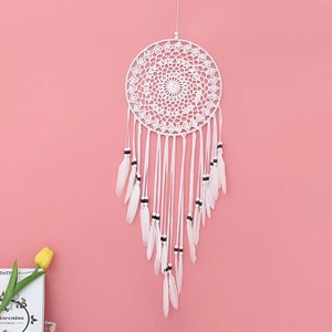 Detailed view of white handmade dreamcatcher with crochet web and soft feathers