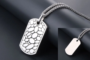 Macro shot of pebble-textured military tag pendant with polished stainless steel back