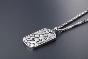 Detail of silver pebble texture on titanium steel dog tag pendant for men