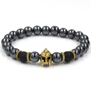 Close-up of men's beaded bracelet featuring gold Spartan helmet and hematite stones