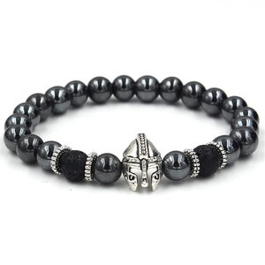 Detailed close-up of Spartan helmet charm on black volcanic stone beaded bracelet