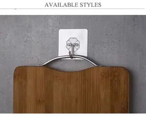 Strong adhesive transparent wall hook holding a wooden cutting board on a tile surface
