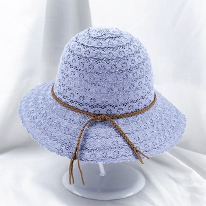 Close-up of lavender lace crochet straw hat with brown decorative bow on white stand