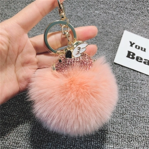 Dettaglio macro del portachiavi a forma di maialino rosa con strass e morbido pompon