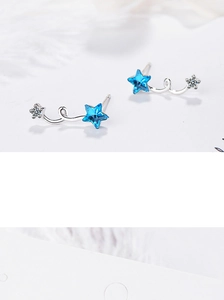Macro shot of blue crystal star earring with silver spiral curve and crystal accents