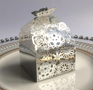 Silver laser-cut candy box with butterfly ornament on a vintage white plate