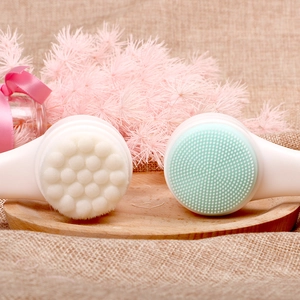 Close-up of dual-sided facial brush with soft bristles and silicone on wooden tray
