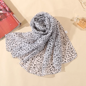 Detail of leopard print chiffon scarf styled with pearls and fashion magazines