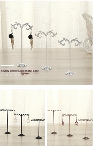 Detailed view of metal earring stands with elegant scroll design in three heights