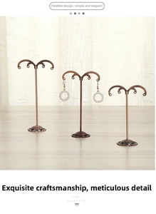 Detailed view of three bronze metal earring display stands with vintage hooks and floral base