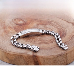 Detail of vintage engraved Cuban link bracelet with micro-pave zircons on a wooden base