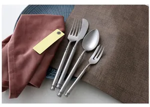 Detail of vintage matte stainless steel cutlery set with embossed ring handles