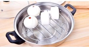 Macro detail of high-legged stainless steel steaming rack inside a metal cooking pot