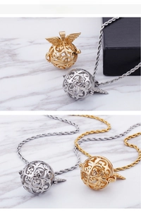 Close-up of hollow spherical oil diffuser pendants with ornate wings in gold and silver