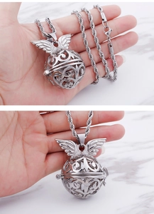 Macro shot of silver winged hollow cage pendant necklace for perfume oil diffusion
