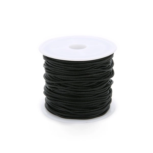 Close-up of black braided cord for jewelry making neatly wound on a white spool