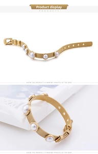 Détail d'un bracelet en maille dorée avec perles blanches et boucle ajustable