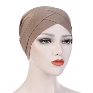 Detail of cross-front khaki stretch turban hat with textured pleats on a mannequin head