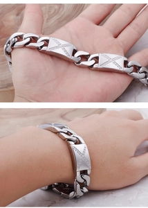 Makroaufnahme des silbernen Panzerkettenarmbands mit X-Steinen am Handgelenk