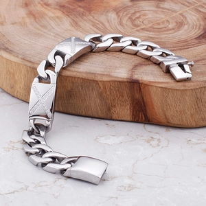 Armband aus Titanstahl mit Zirkon-Inlay und X-Muster-Verschluss auf Holz-Hintergrund