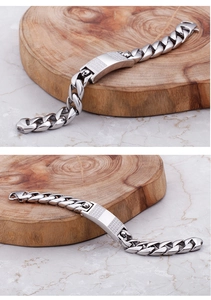 Detail of silver men's Cuban chain bracelet featuring skull emblem and iced-out rhinestones