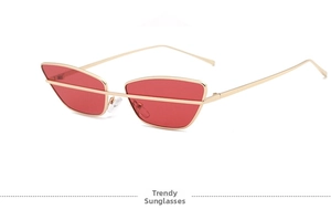 Detail of red lenses cat-eye sunglasses with gold metal frame and horizontal bar
