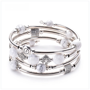 Detail view of multi-layer wrap bracelet with natural howlite beads and engraved metal spacers