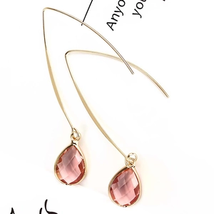 Detailed view of pink teardrop crystal earrings with elegant gold hook fasteners