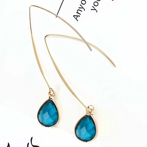 Detailed view of dark blue teardrop crystal earrings with elegant gold hook closure